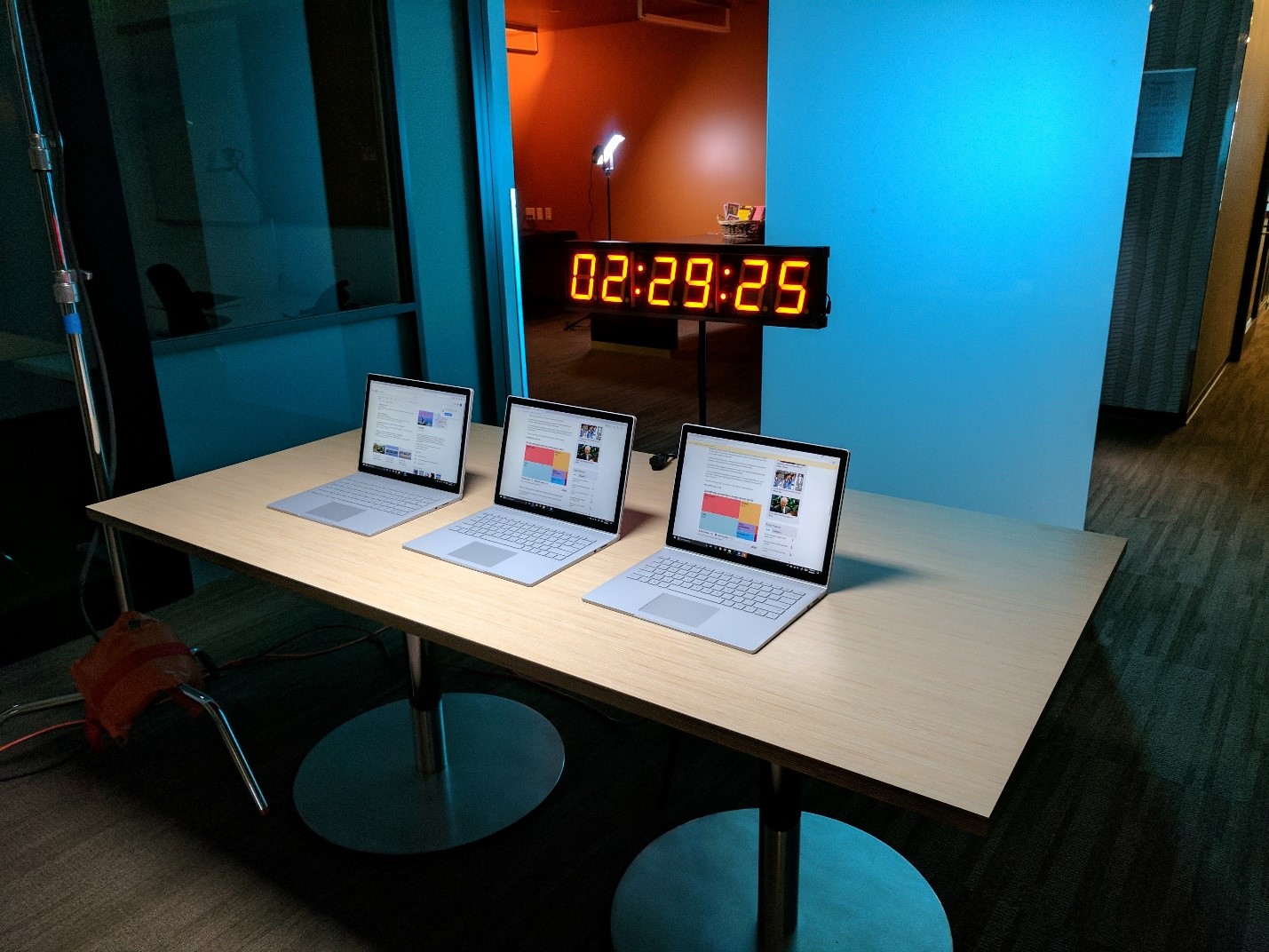 Surface Books instrumented for direct power measurement, running a looping browser test in a performance lab.