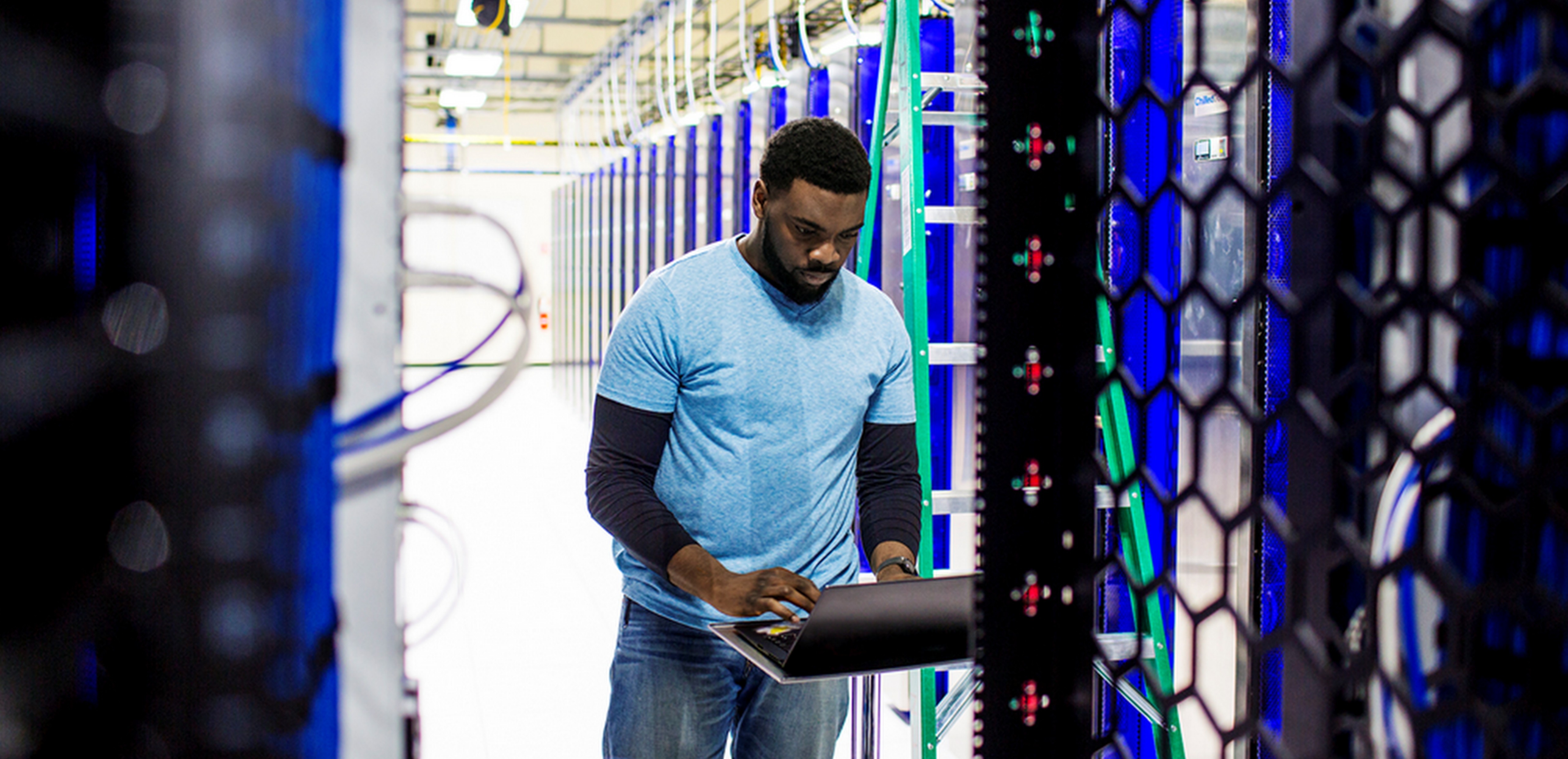 IT pro standing in a data center working on a PC