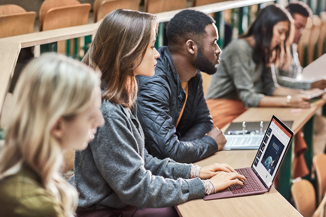 Students in a classroom, with one working on a Surface