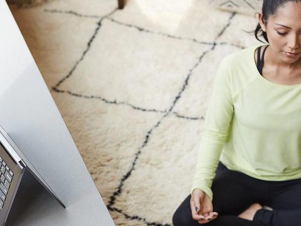 Woman meditating next to a mobile device