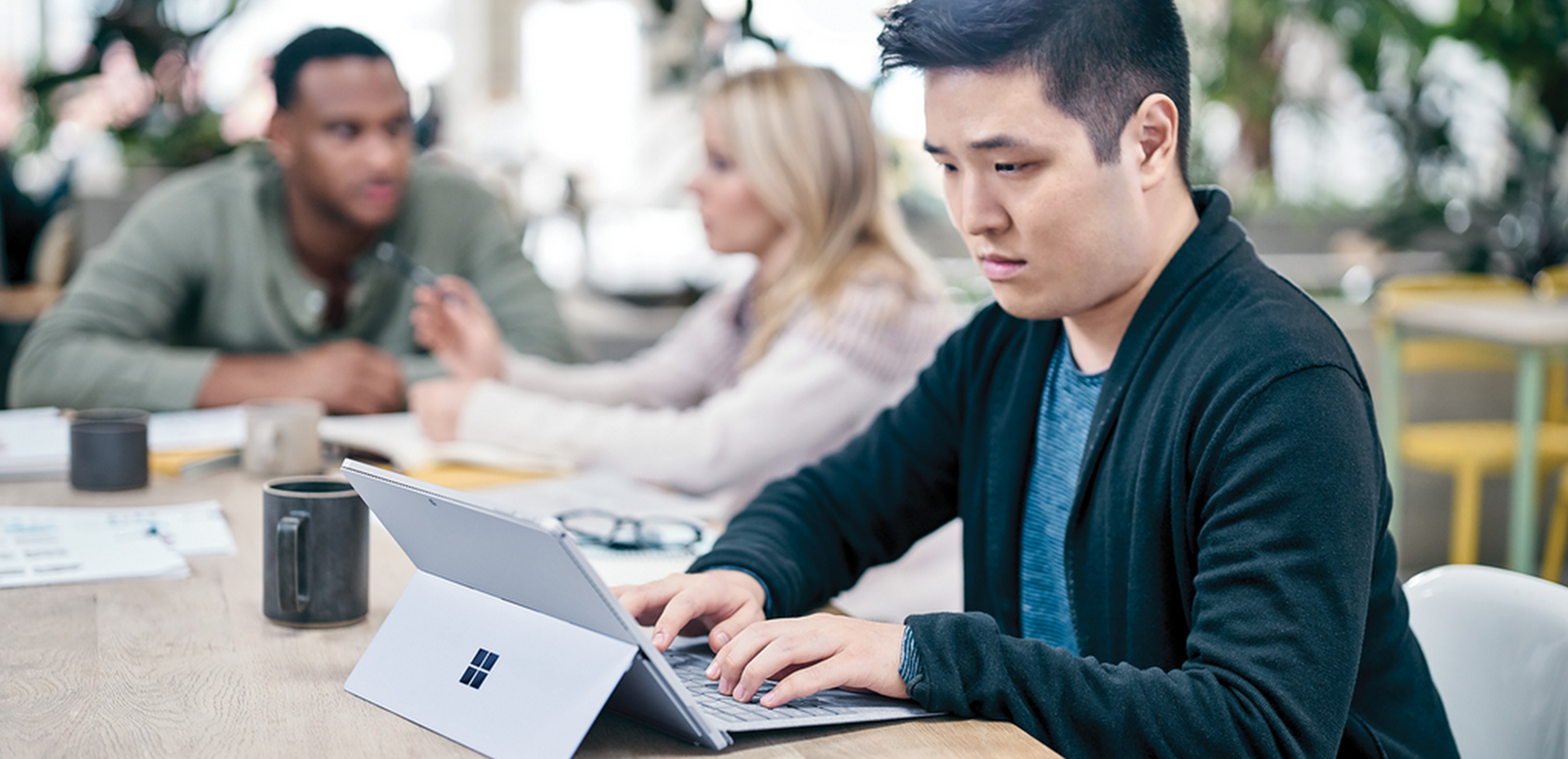 Man sitting at a desk working on a Surface Pro 4