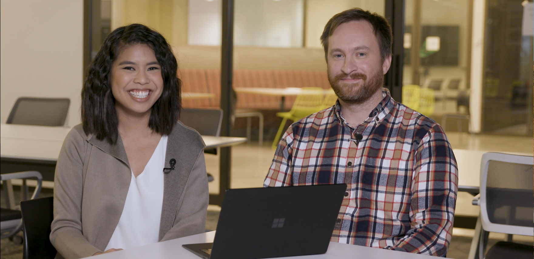 Two Microsoft writers sitting in front of their laptops