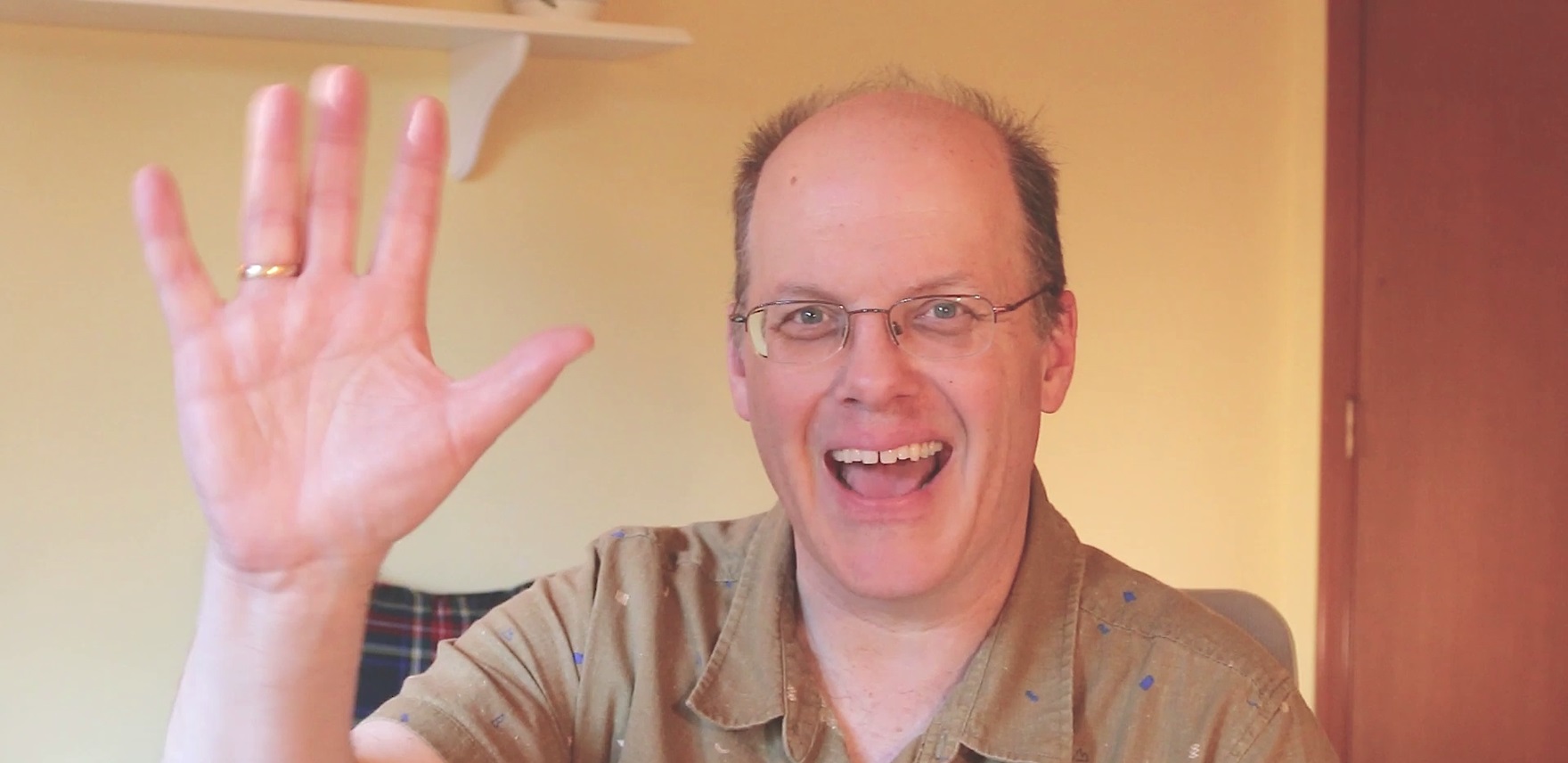 Dough Thomas smiling and waving at the camera