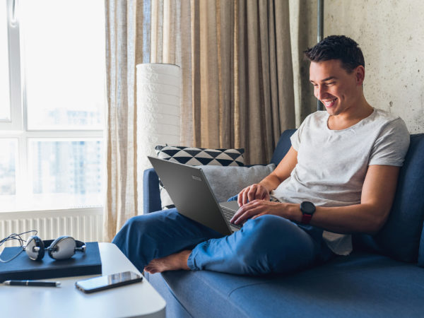 Man sitting on couch using Acer TravelMate P4 on lap