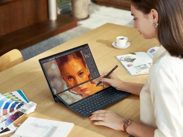 Woman working on a ZenBook Duo with another woman's face crossing both screens