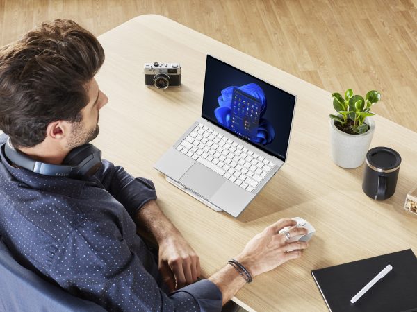 Man sitting at a desk with a laptop open in front of him, as seen from above and to the left