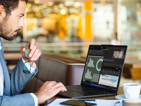 Man with hand paused over keyboard of a laptop