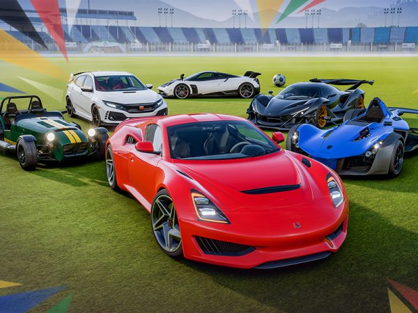 Six racing cars parked on a soccer field