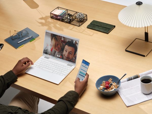Woman sitting at a desk on a video chat with a man and woman