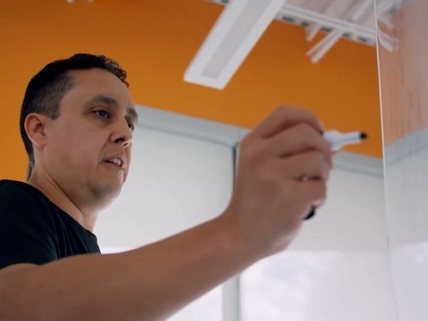 Man standing at a whiteboard with marker in hand about to write on it
