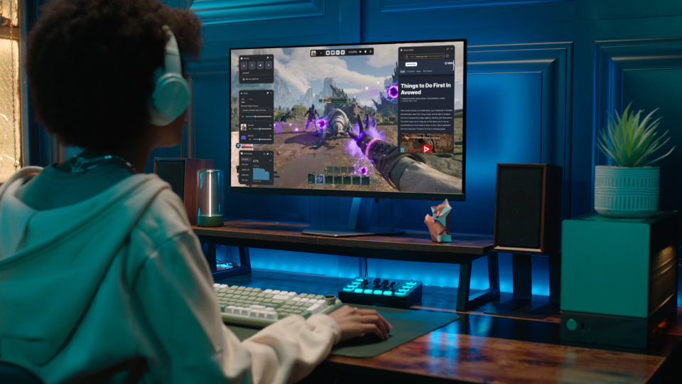 View from behind of a gamer wearing a headset and playing in front of a monitor.