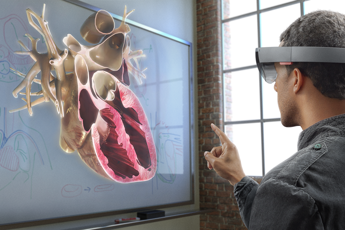 A man using Microsoft HoloLens in a classroom setting.