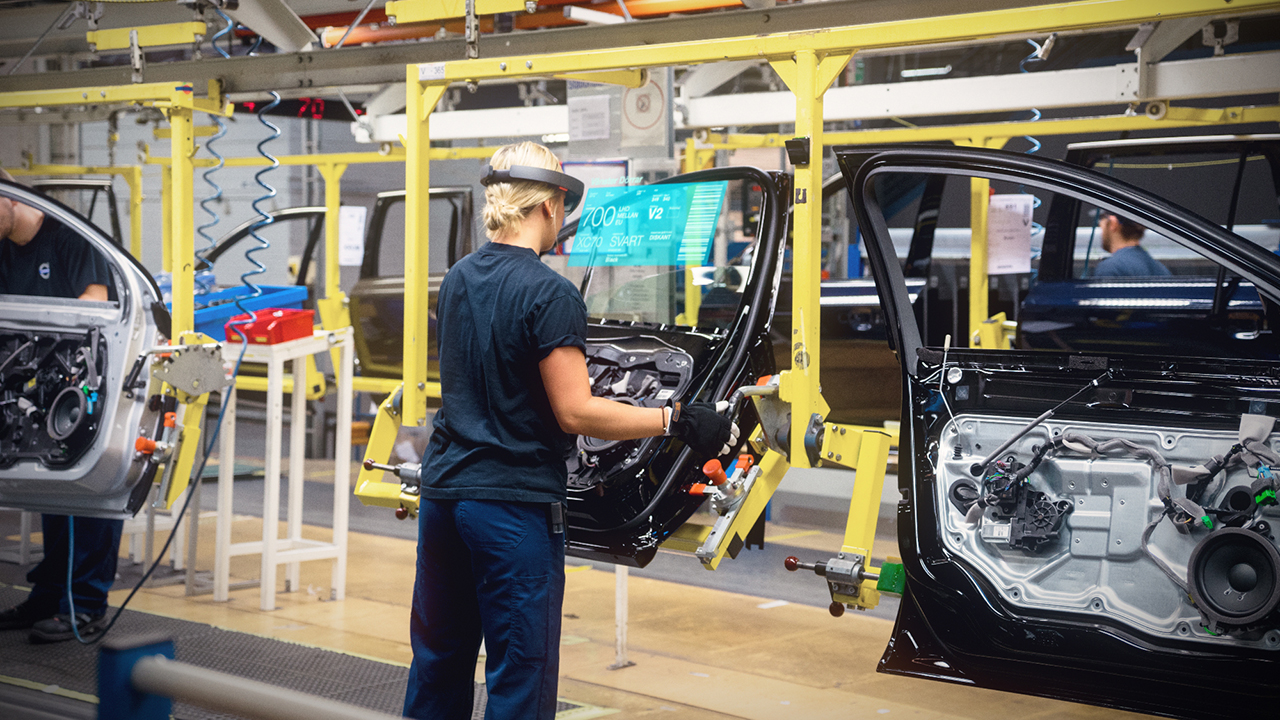 A woman working on a car assembly line using Microsoft HoloLens.