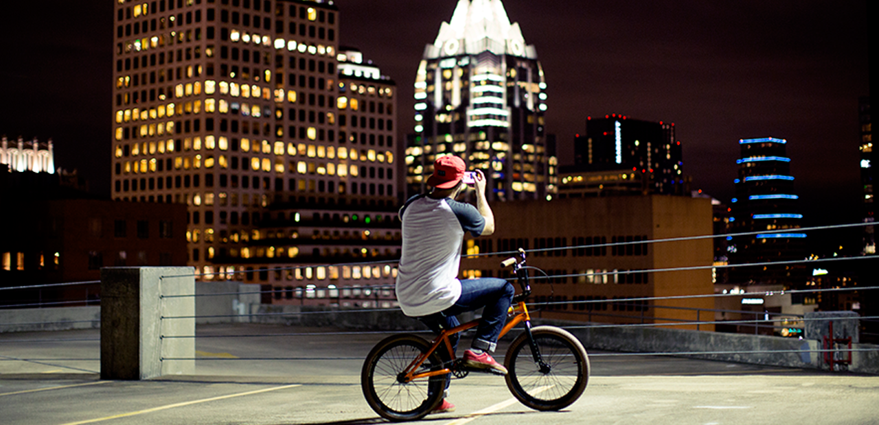 Man on bicycle taking photos with Lumia smartphone.