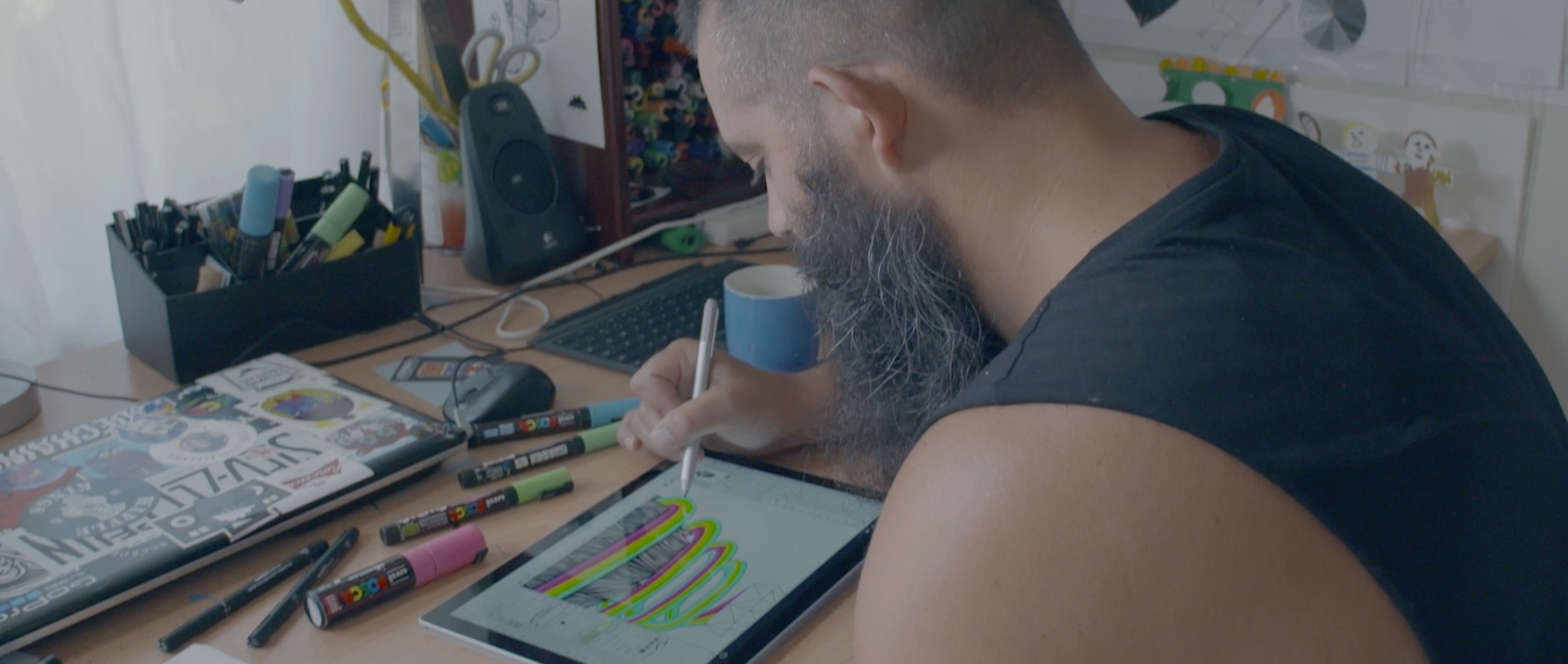 Mural artist Mulga drawing his mural on his Surface.