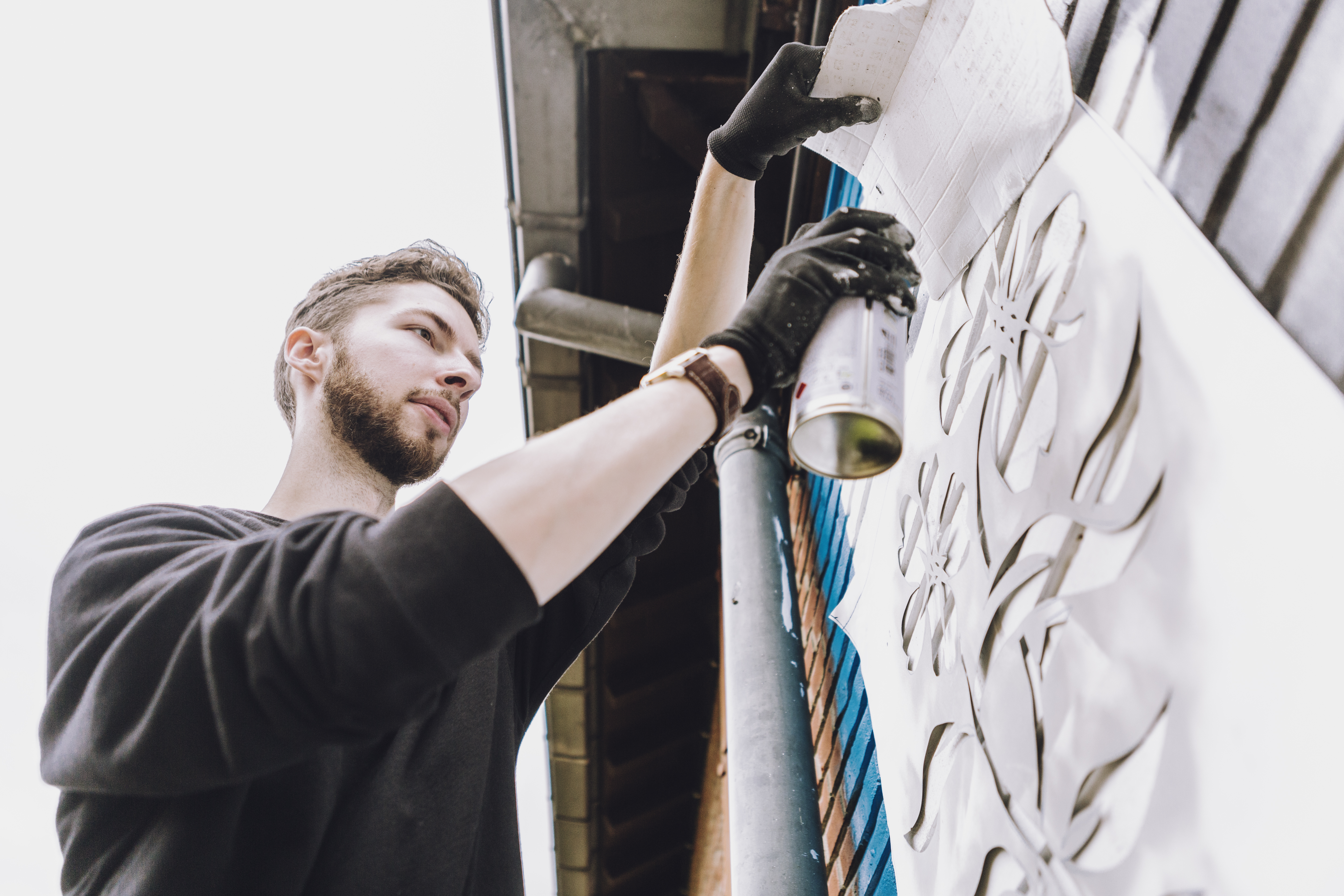 Noir spray painting his mural.