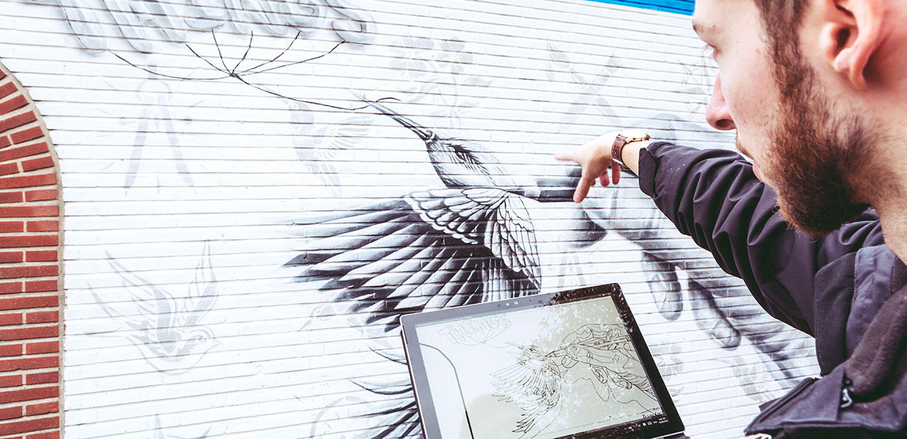 Noir, muralist from Belgium, working on his mural using Surface.