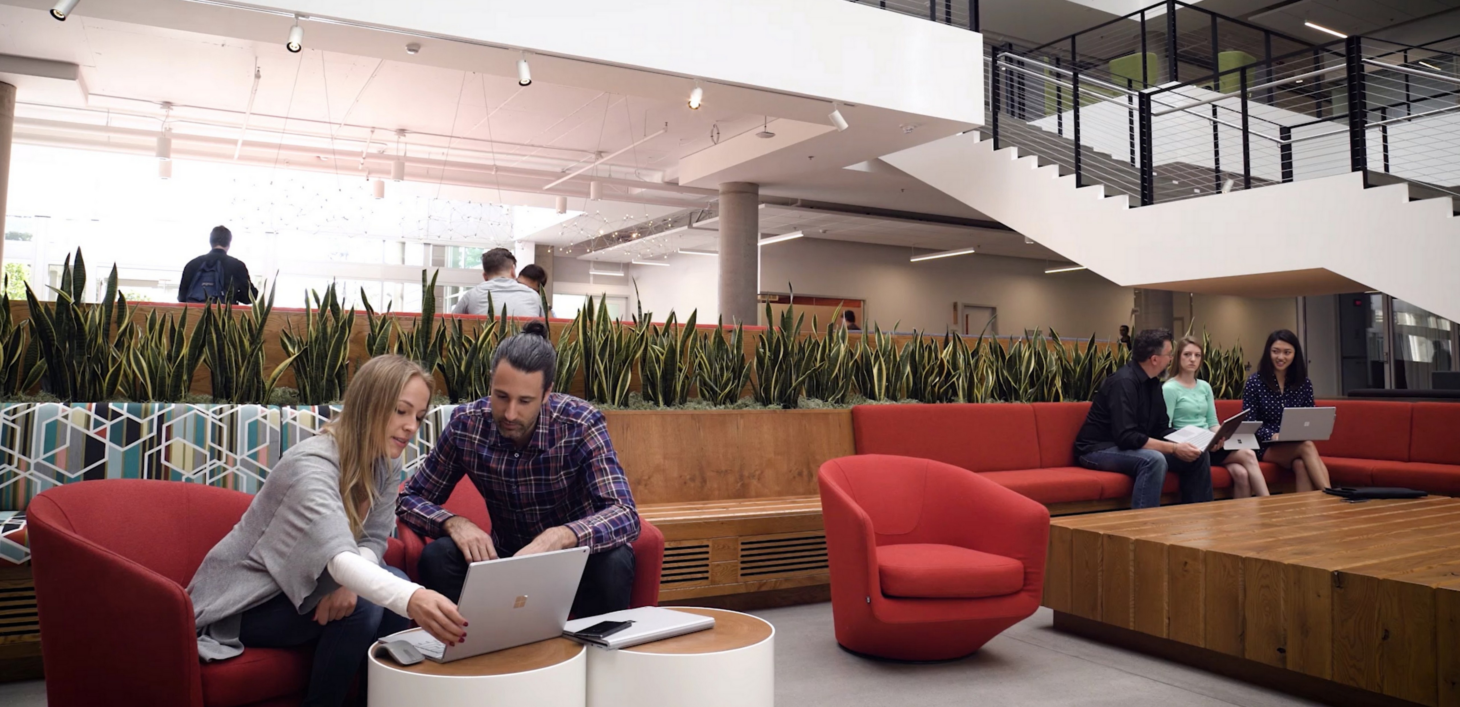 Man and woman collaborating and working together on a Surface Book
