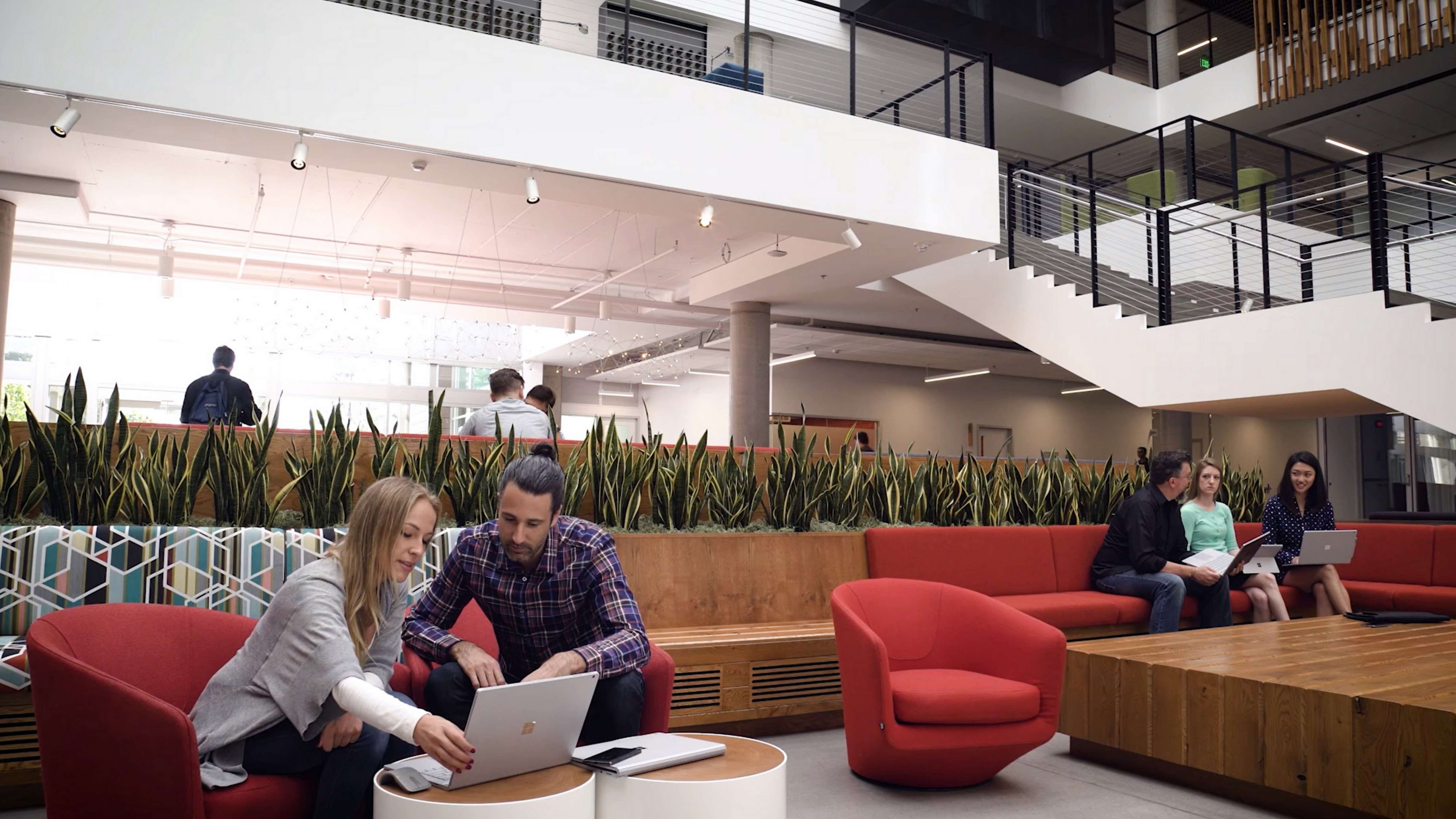 Man and woman collaborating and working together on a Surface Book