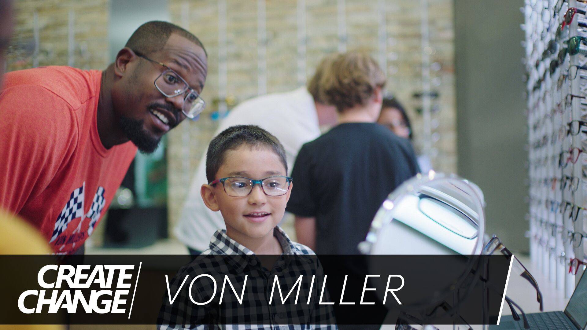 NFL player Von Miller trying on glasses with a young boy.
