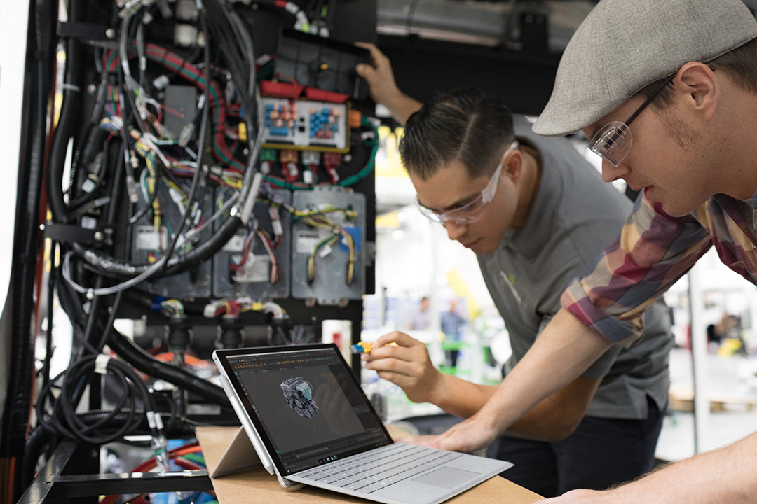 Two men working in a shop on the new Surface Pro.