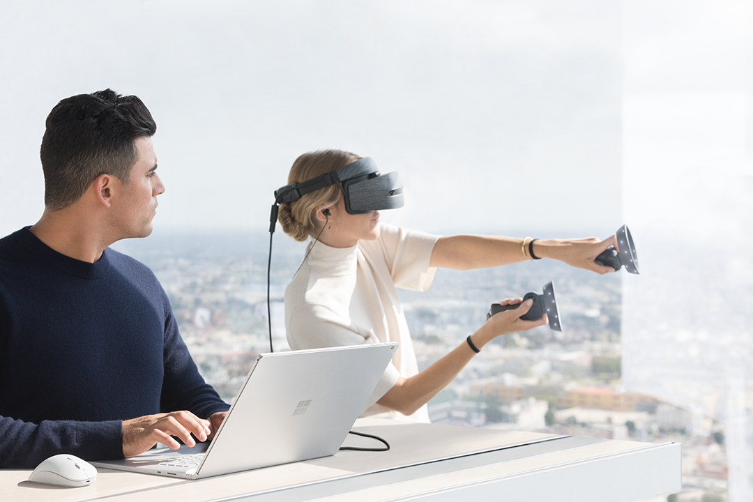 Woman wearing Windows Mixed Reality headset running on the new Surface Book 2