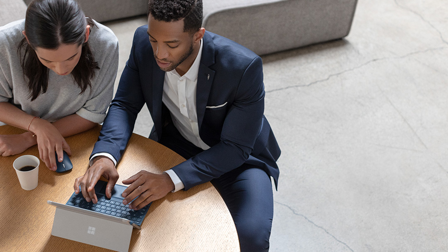 Man and woman working on a Surface Go device