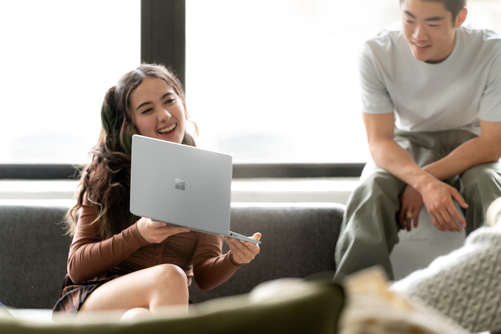 a person shows the screen of their laptop to a second person