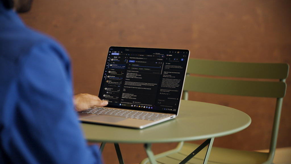 A person's hand reaching out to a laptop keyboard.